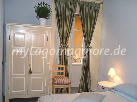 Schlafzimmer mit Doppelbett und 2 Schränke und Ausgang zum kleinen Balkon mit Seesicht